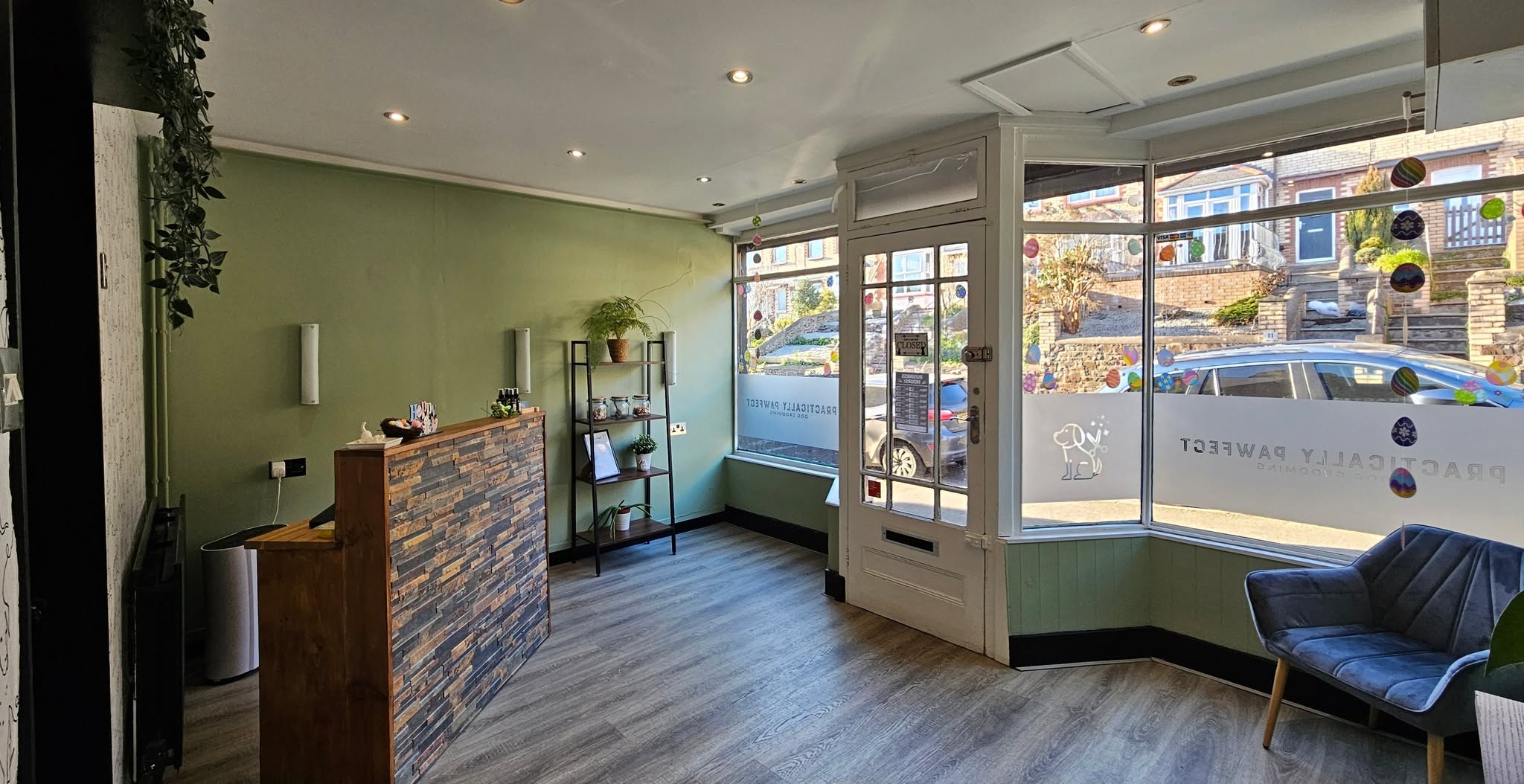 Inside the salon: green walls, a stone-clad reception desk and frosted windows with our logo