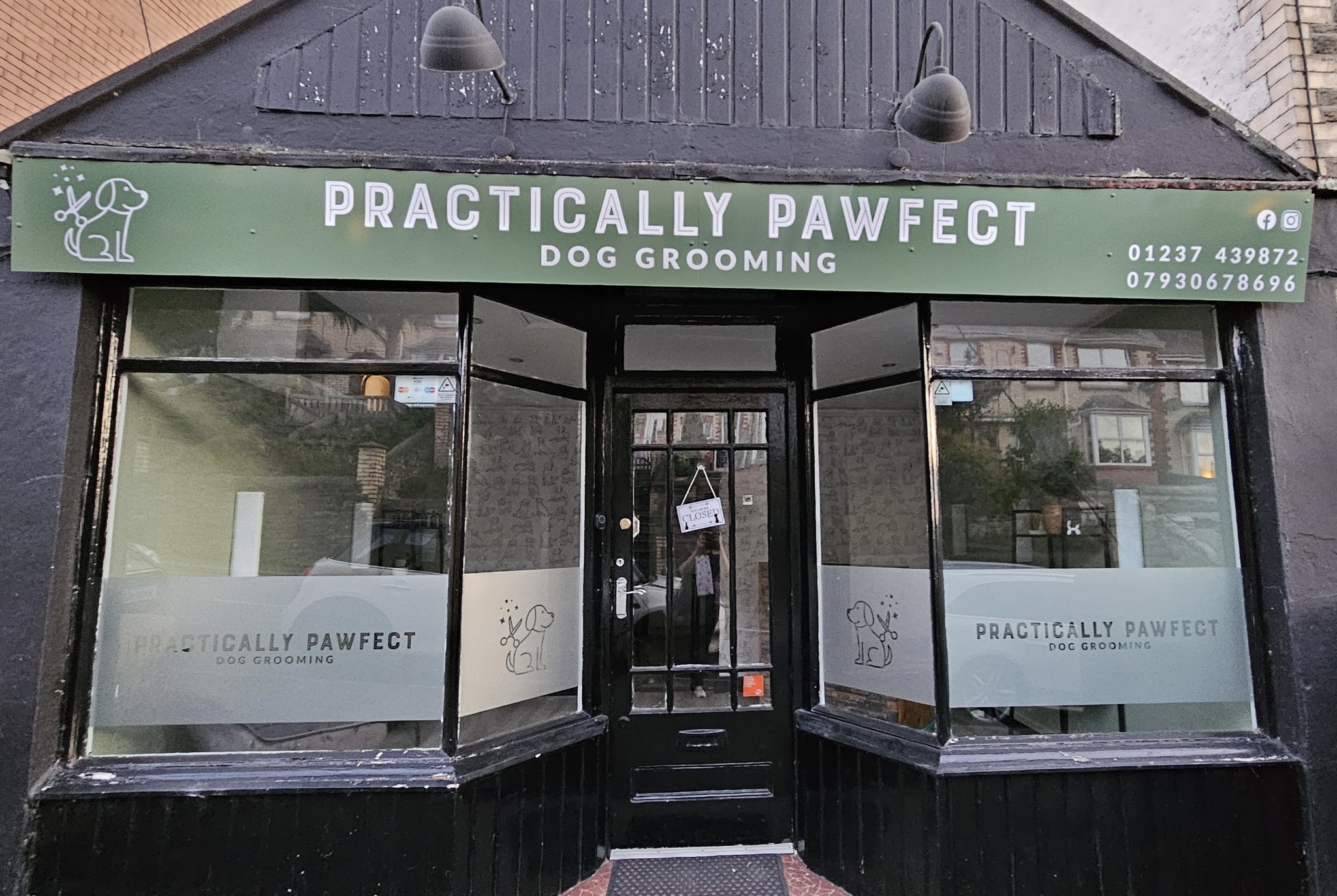 The Practically Pawfect shopfront with its green sign reading Dog Grooming